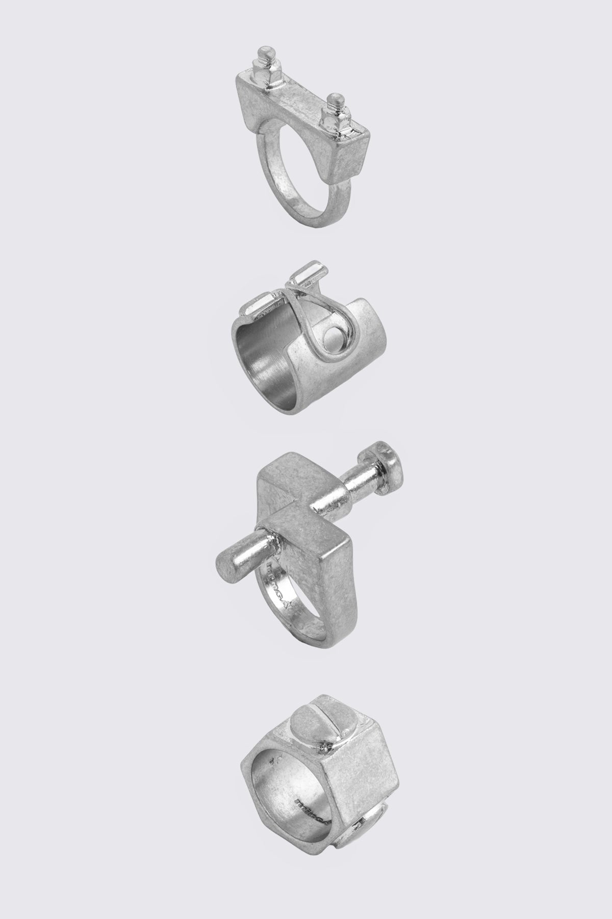 Silver zinc ring set with chunky hardware-inspired bands and oxidized finish in a grunge aesthetic.