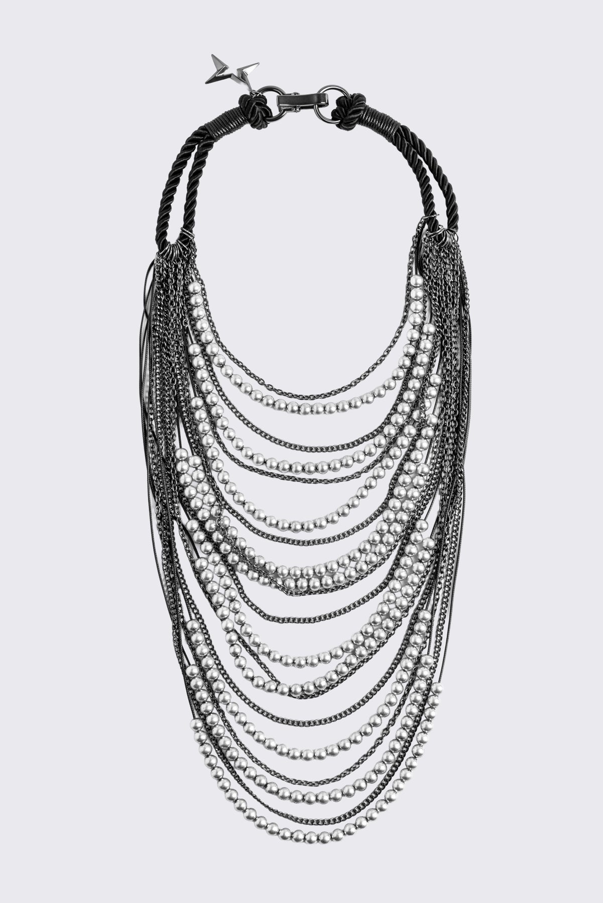 Silver layered chain necklace with beaded and curb chain strands, black knotted cord straps and charm pendant.