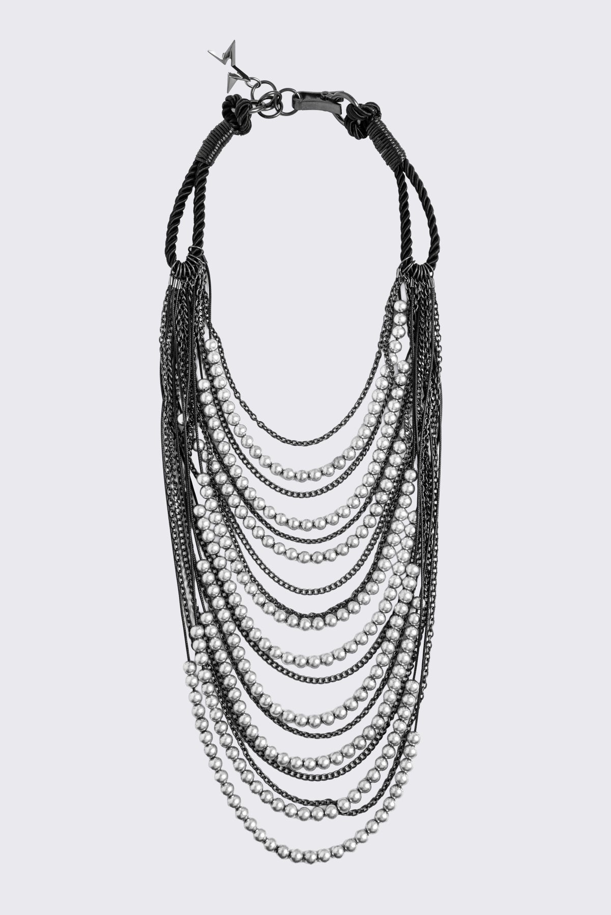Silver layered chain necklace with beaded and curb chain strands, black knotted cord straps and charm pendant.