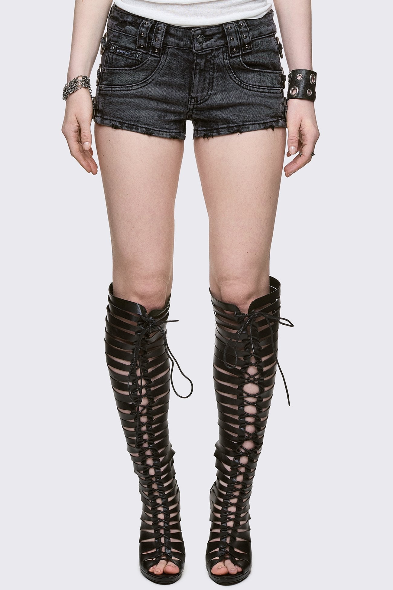 Black washed denim hot pants with silver O-ring, stud and distressed details. 