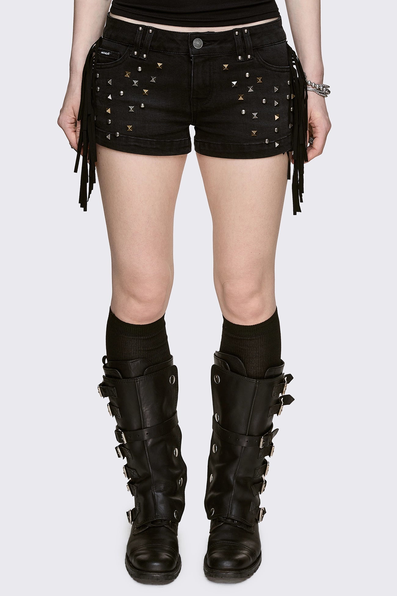 Black denim micro shorts with mixed studs and side fringe, low-rise fit in a grunge Y2K style.