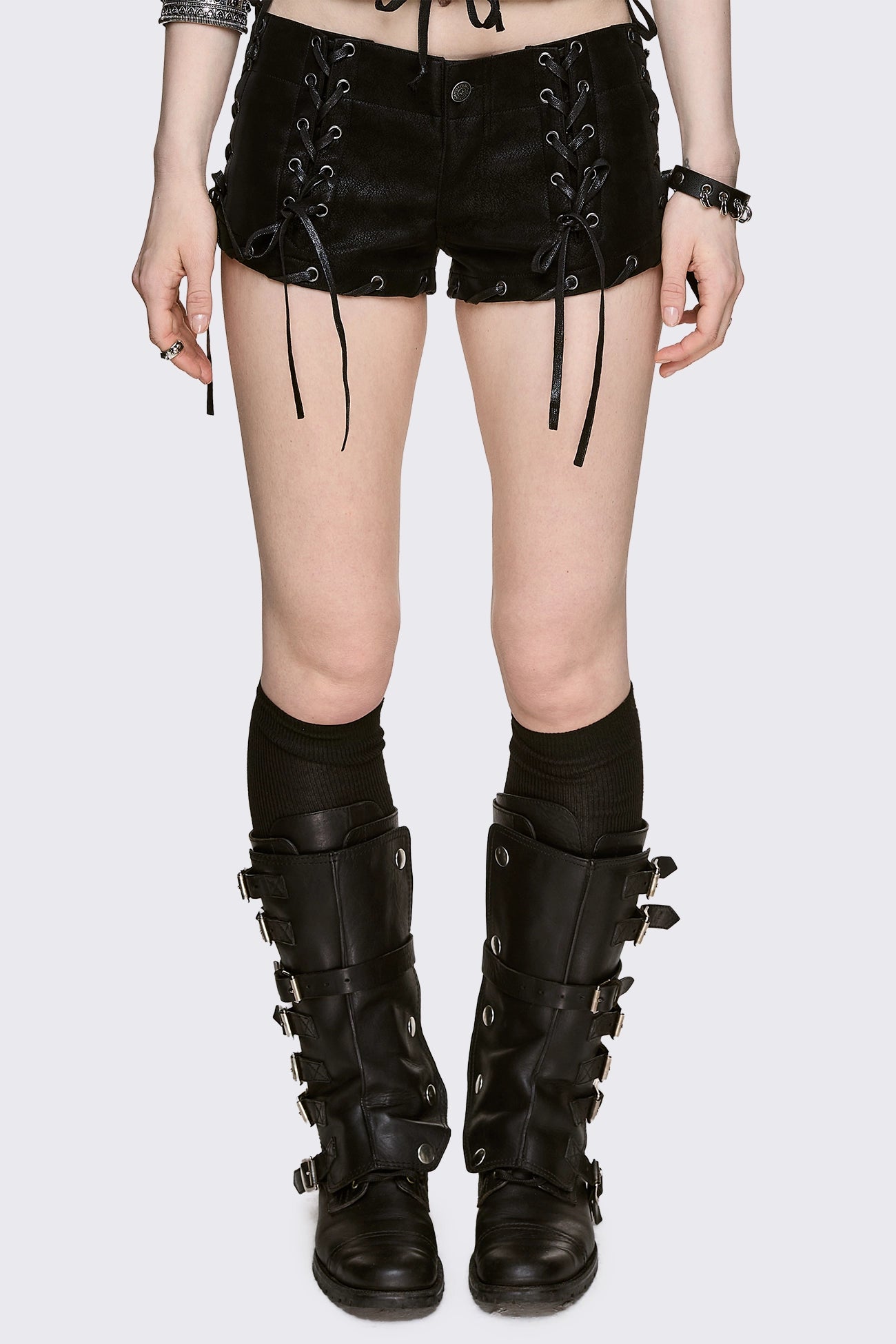Black vegan suede micro shorts with front and side lace-up details, low-rise fit in a grunge goth style.
