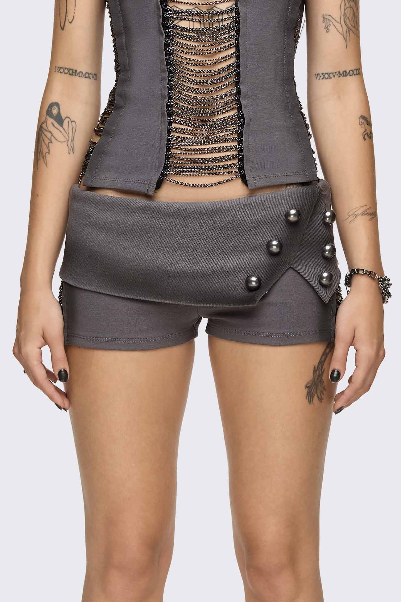 Grey washed jersey hot pants with side cutouts, silver chains and a studded fold-over low rise waistband.
