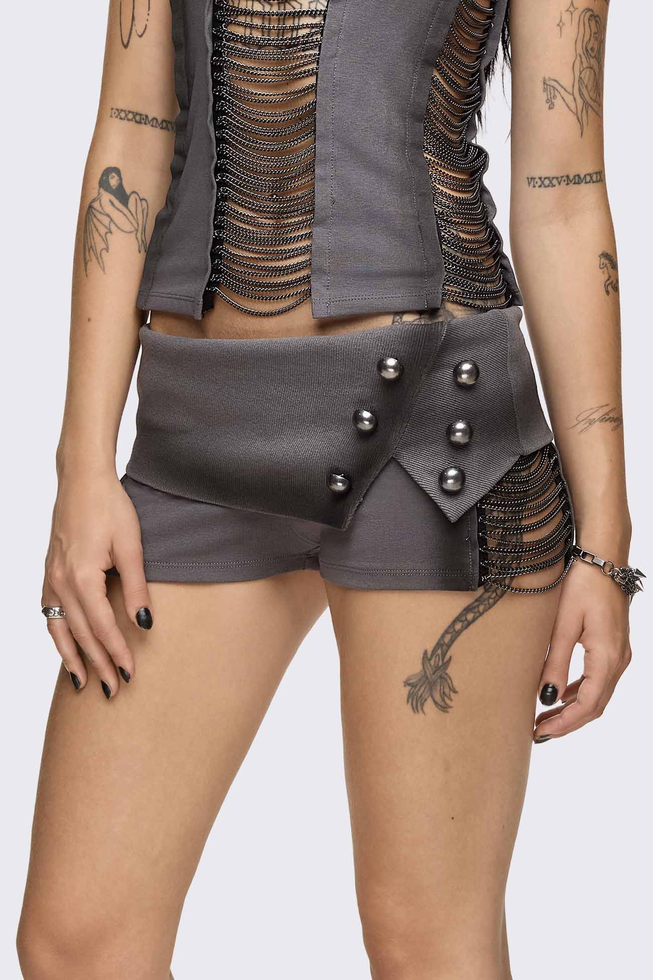 Grey washed jersey hot pants with side cutouts, silver chains and a studded fold-over low rise waistband.