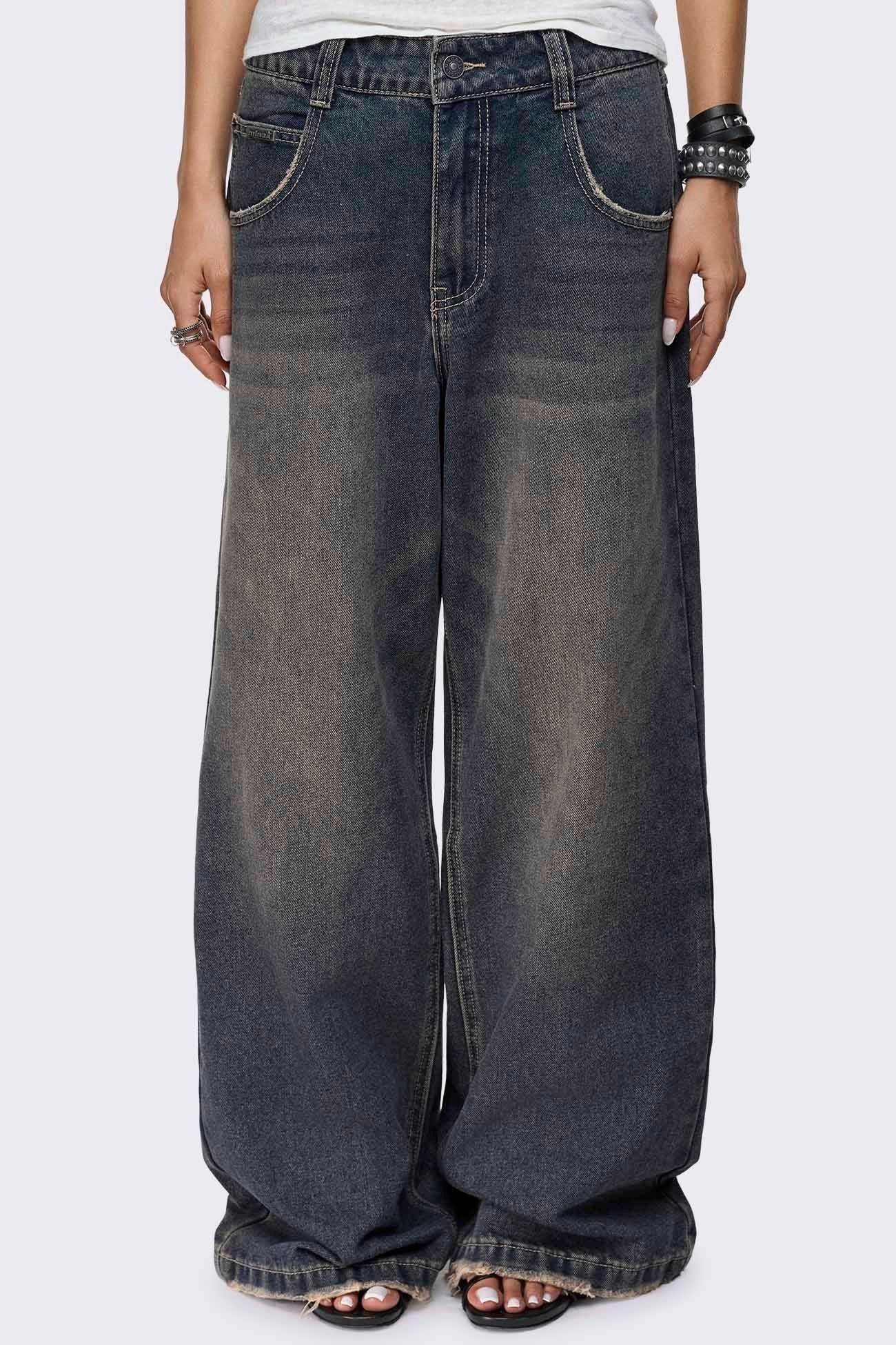 Washed dirty blue jeans with a faded finish, low-rise waist, straight baggy leg and five-pocket design.