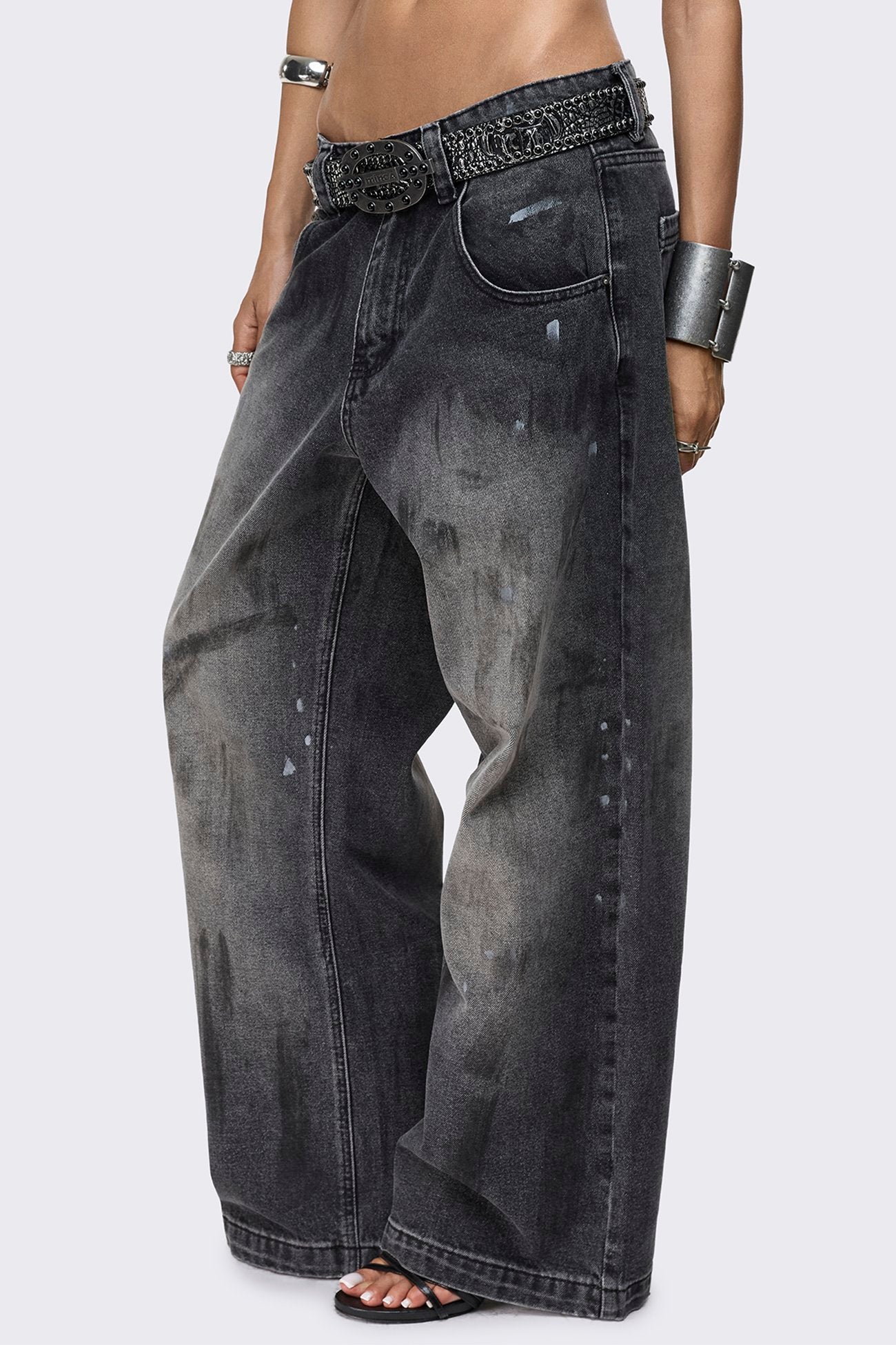 Faded black baggy jeans with paint splatter detail, distressed finish, low-rise waist and straight leg fit.