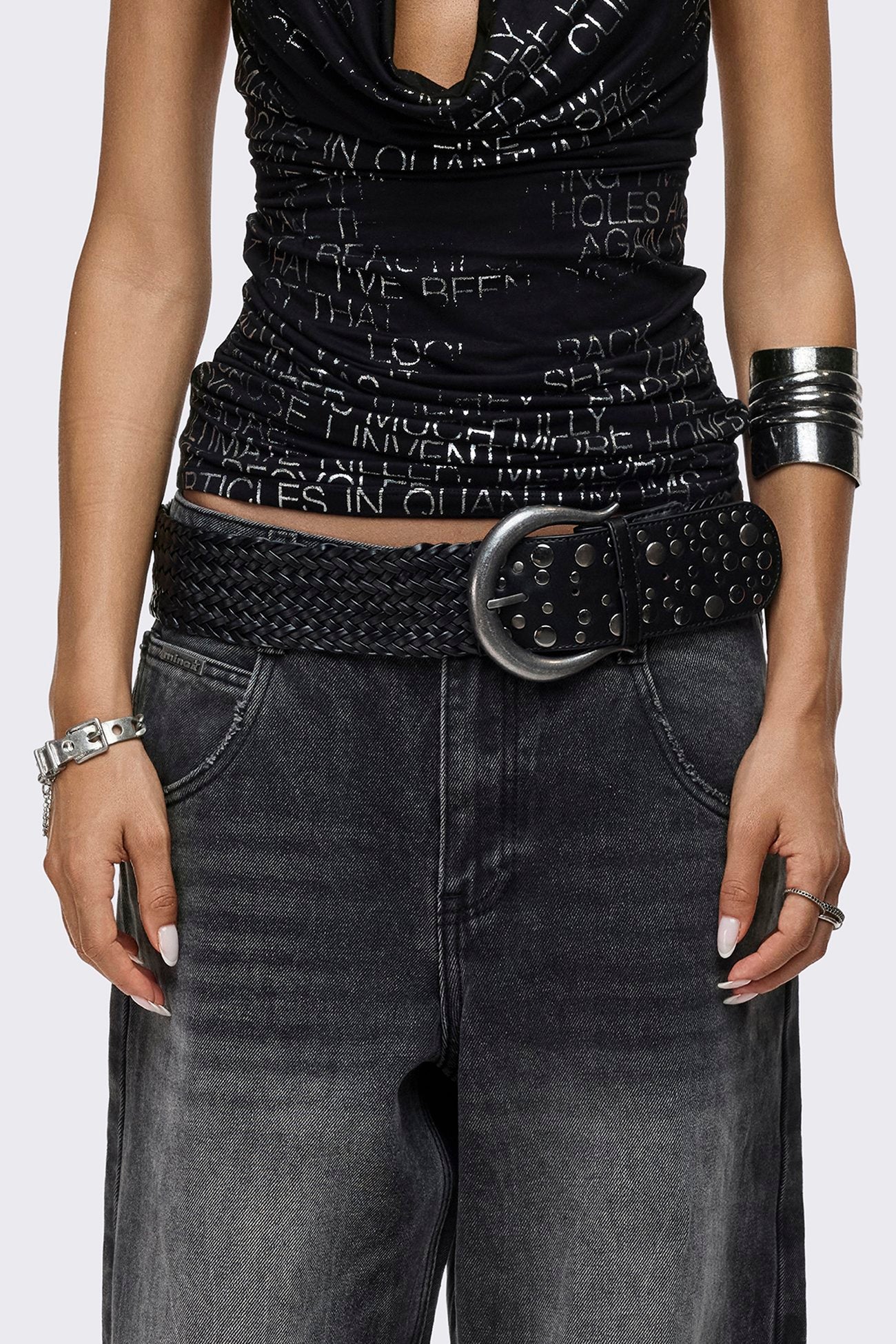 Black braided vegan leather belt with studded detail and antique silver buckle fastening.