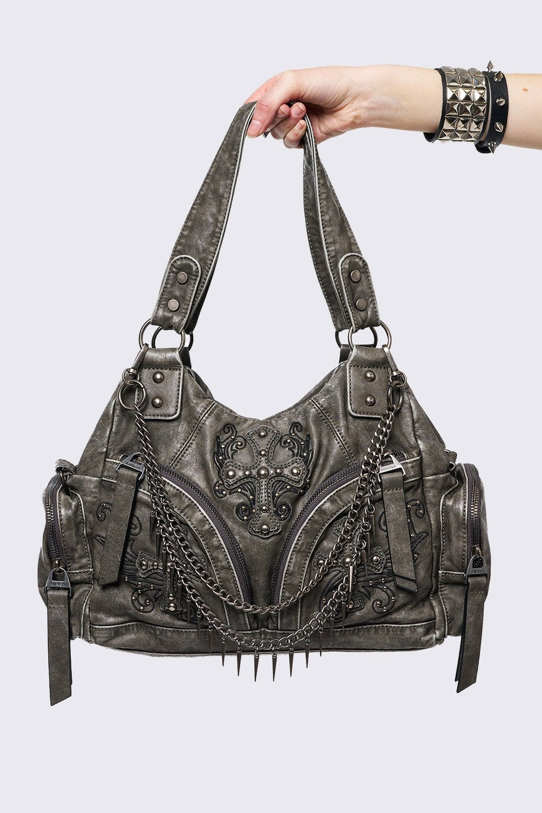 Grey washed faux leather shoulder bag with studded cross patches, spikes and chains accents. Multiple pockets and grunge-style.