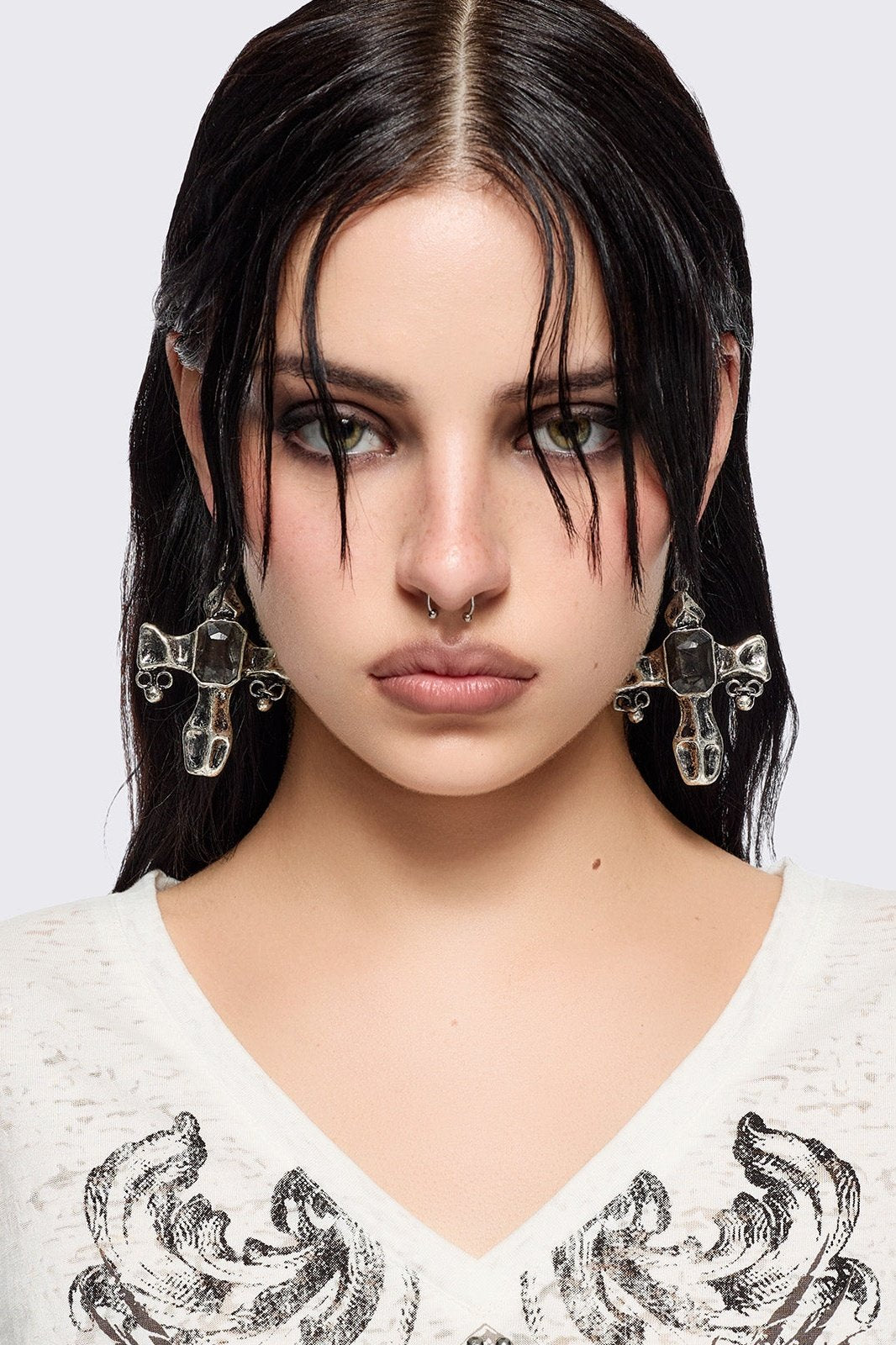 Silver dangle earrings with cross pendants featuring black stone details.