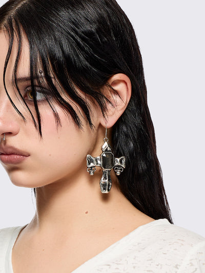 Silver dangle earrings with cross pendants featuring black stone details.
