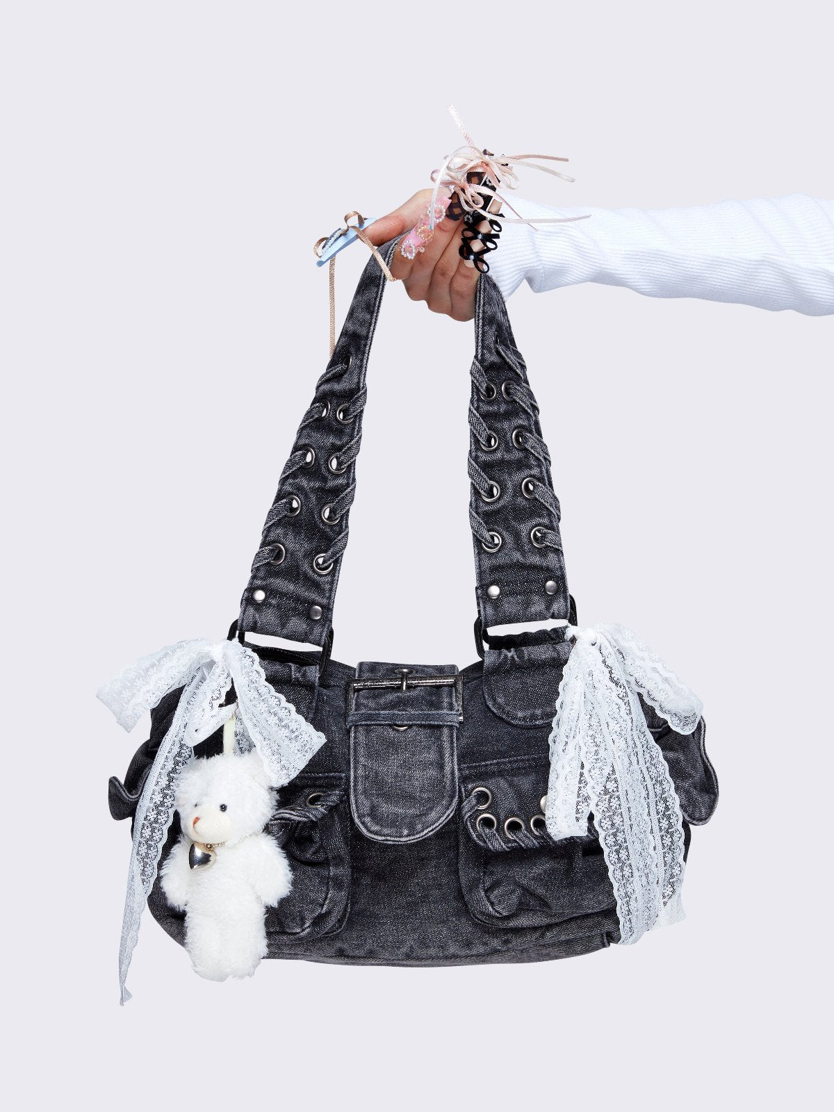 Washed grey shoulder bag with lace-up strap details, lace bow accents, front pockets, and a cute teddy bear keychain. Perfect for Y2K and alternative fashion styles.