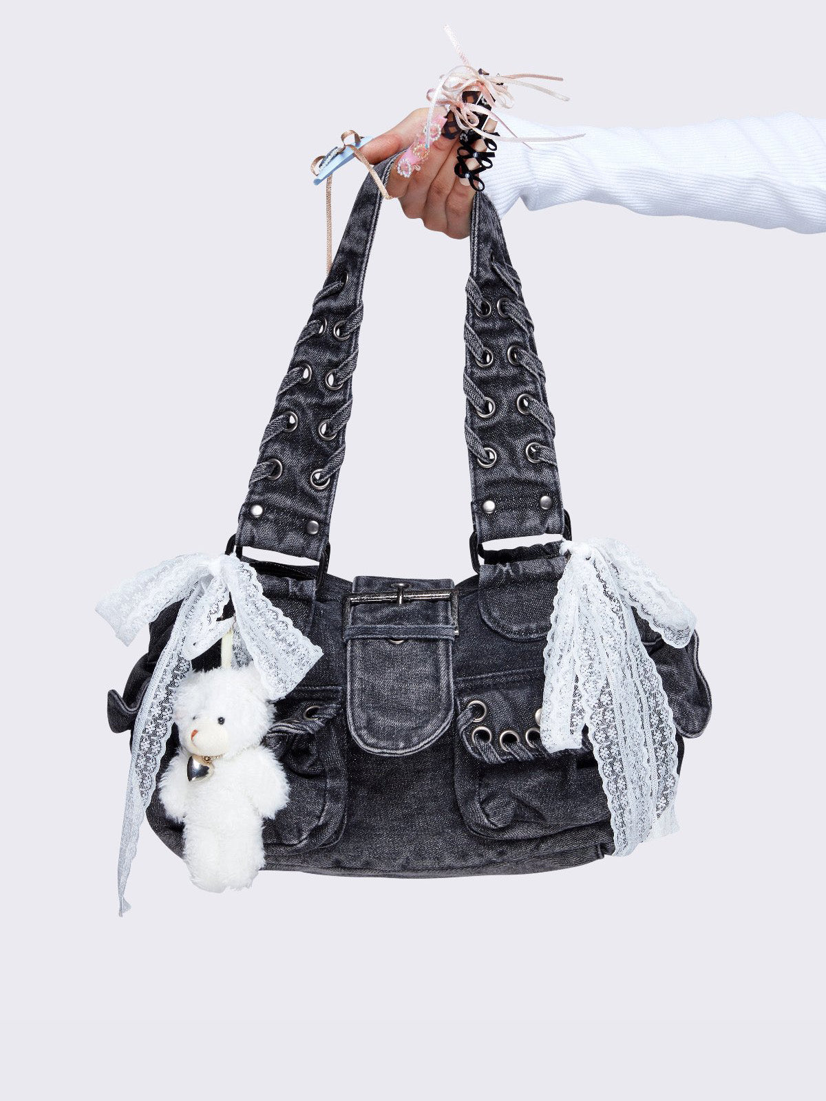Washed grey shoulder bag with lace-up strap details, lace bow accents, front pockets, and a cute teddy bear keychain. Perfect for Y2K and alternative fashion styles.