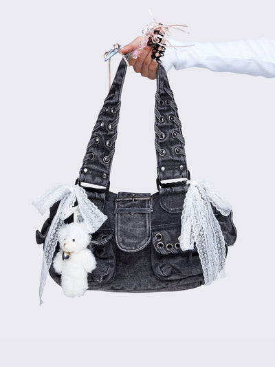 Washed grey shoulder bag with lace-up strap details, lace bow accents, front pockets, and a cute teddy bear keychain. Perfect for Y2K and alternative fashion styles.
