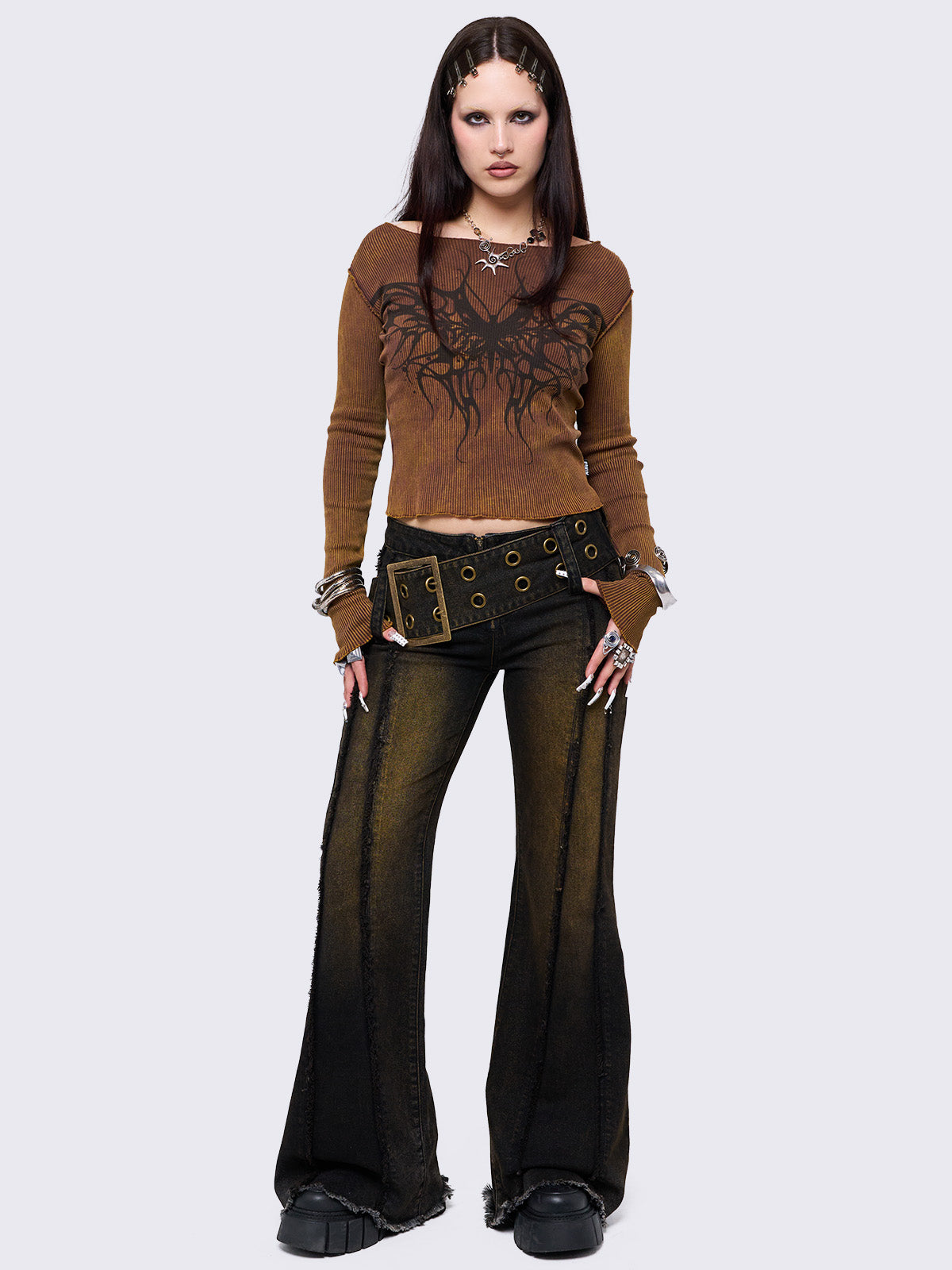 Black flared jeans featuring a honey overdye wash, a chunky buckle belt, distressed seams details and raw frayed hems. 