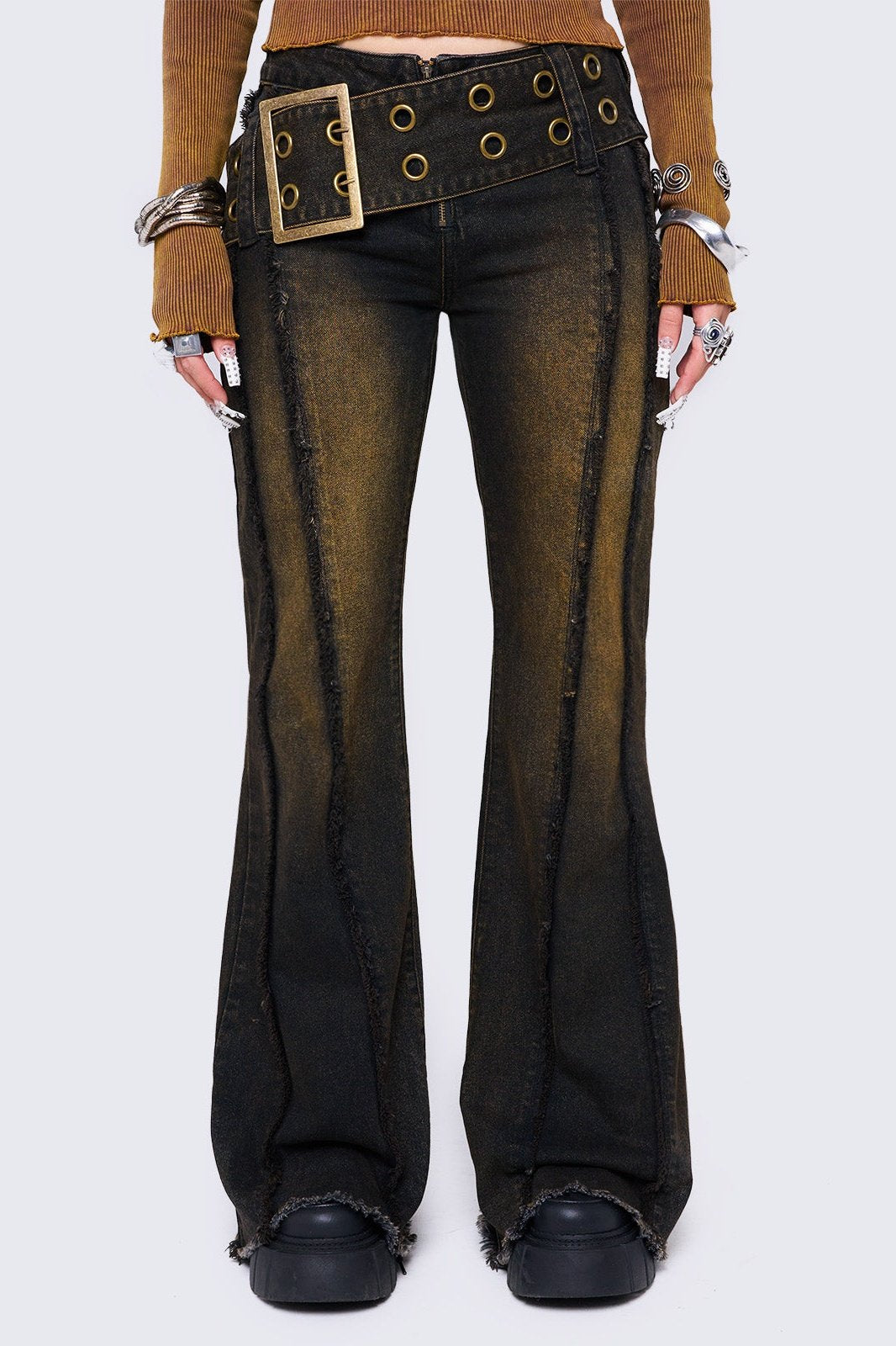 Black flared jeans featuring a honey overdye wash, a chunky buckle belt, distressed seams details and raw frayed hems. 