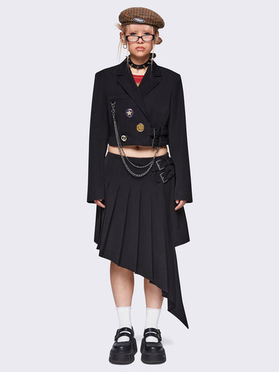 Pleated asymmetric midi skirt in black with double buckle and wrap effect.