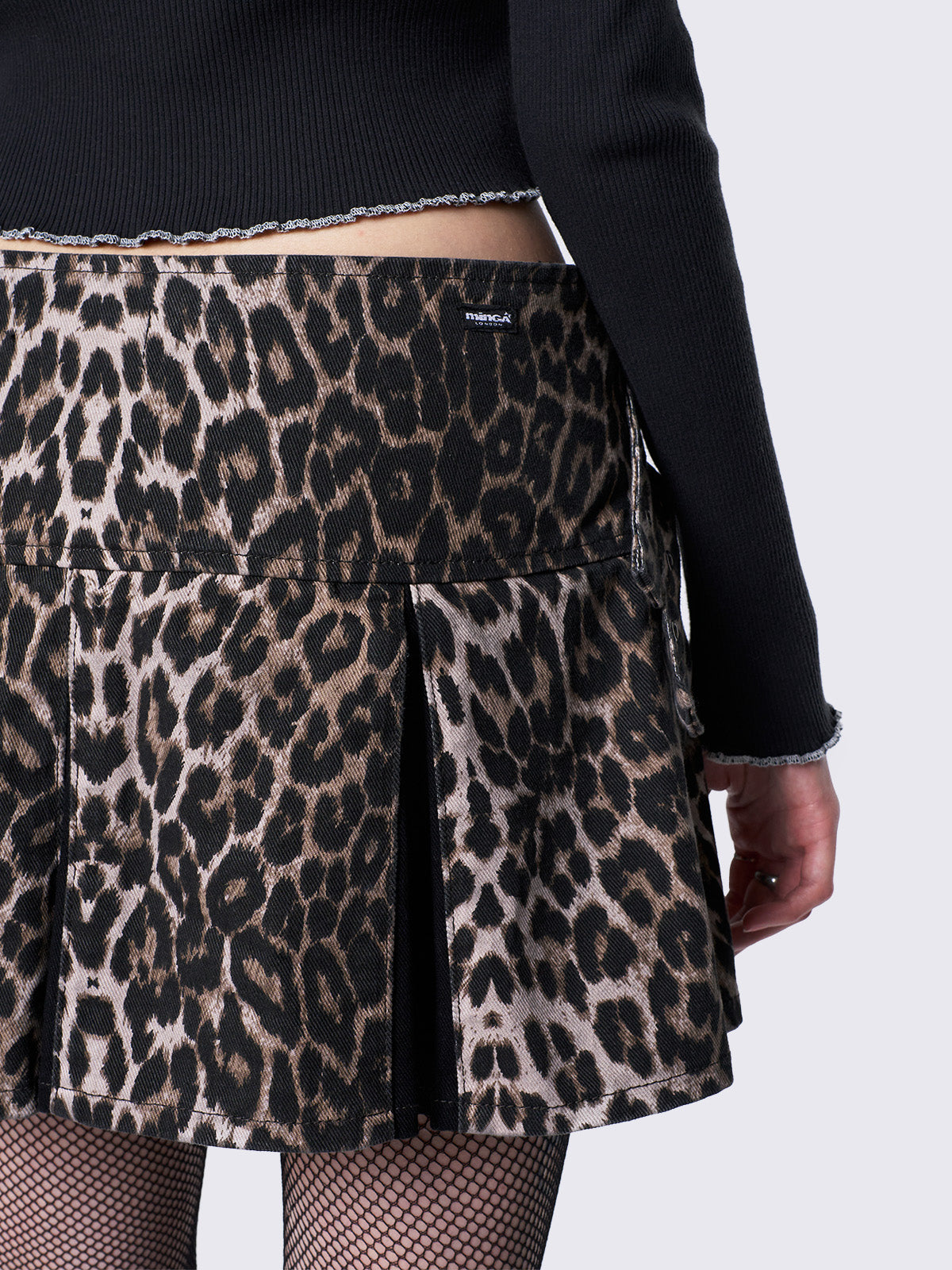 Pleated mini skirt in leopard print, contrast pleats in black and buckle straps and D-rings details.