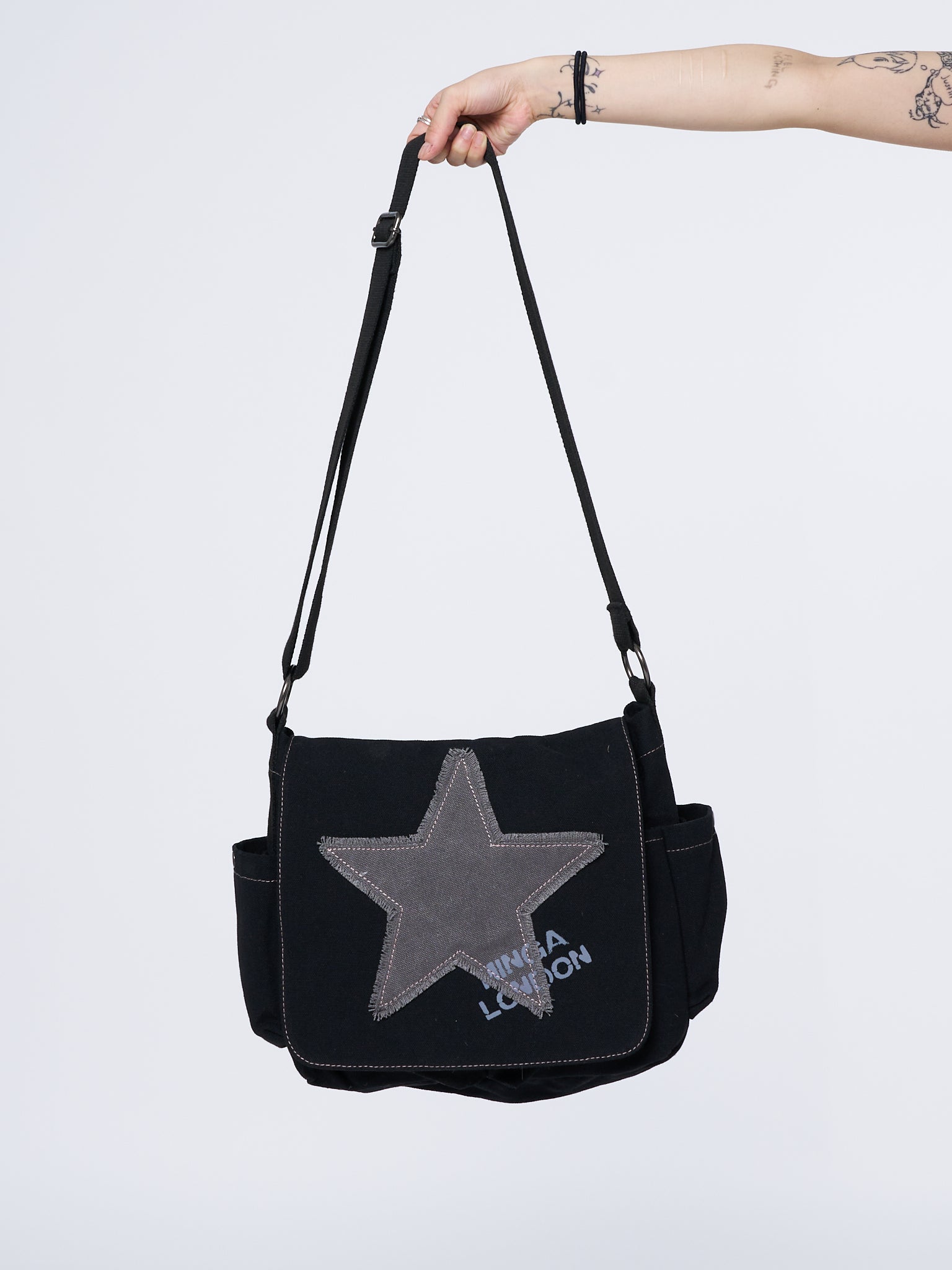 Grunge-inspired Y2K canvas messenger bag in washed black with Minga star front print in grey.