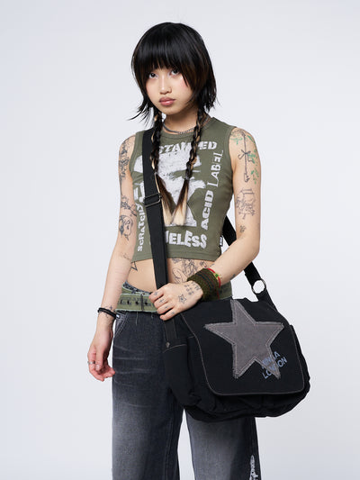 Black canvas messenger bag by Minga London. Featuring a Super Star design. Stylish and practical accessory for carrying essentials with flair.
