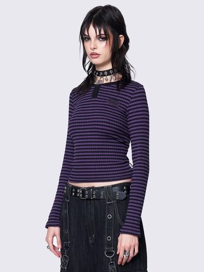 Slim-fit ribbed top with purple and black stripes, half button placket, Minga embroidered logo, and rounded neckline. Y2K and grunge-inspired style