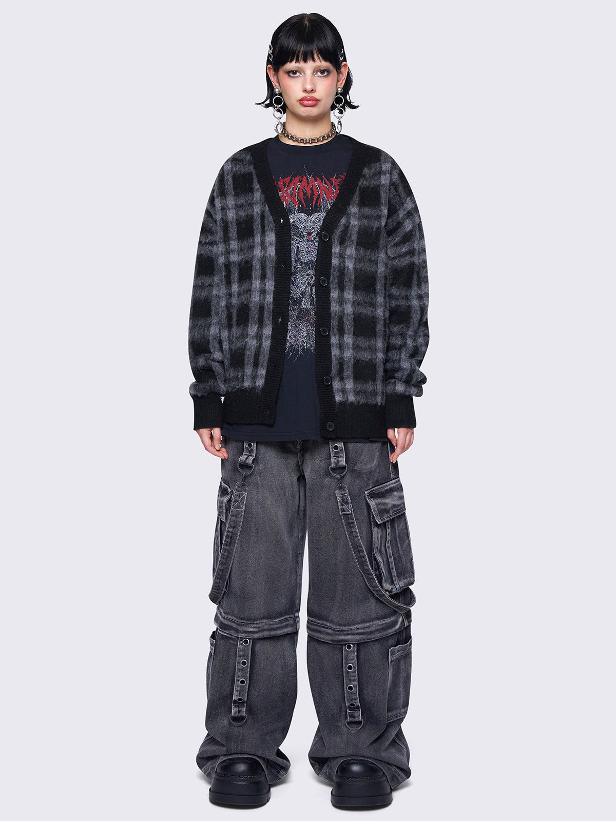 Black and grey plaid oversized cardigan, featuring a soft fuzzy texture and button-down front, paired with graphic t-shirt for an alternative fashion look.