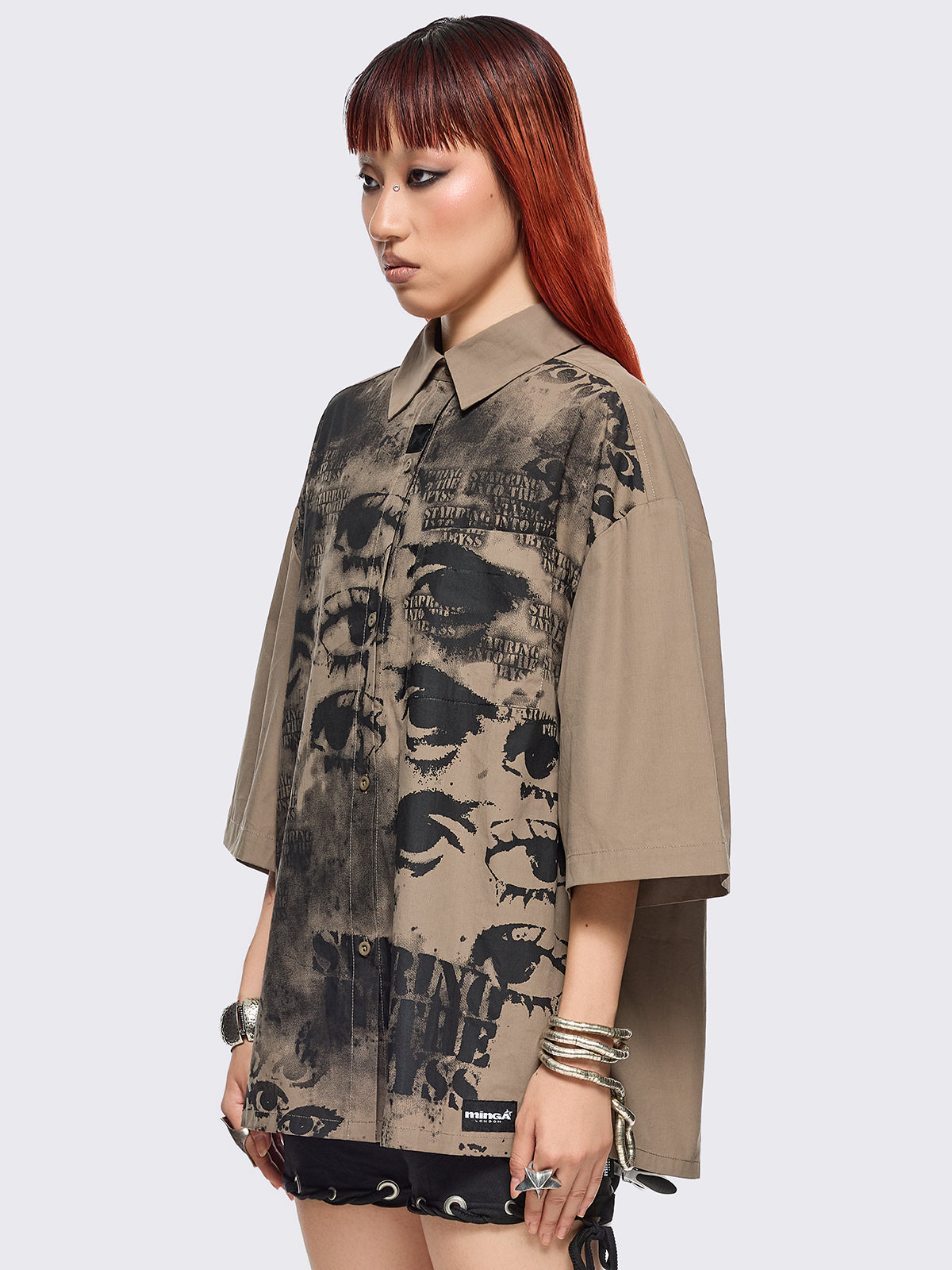 Stone short sleeve shirt featuring a black eyes and lettering graphic print, chest pocket, drop shoulders and oversize fit.