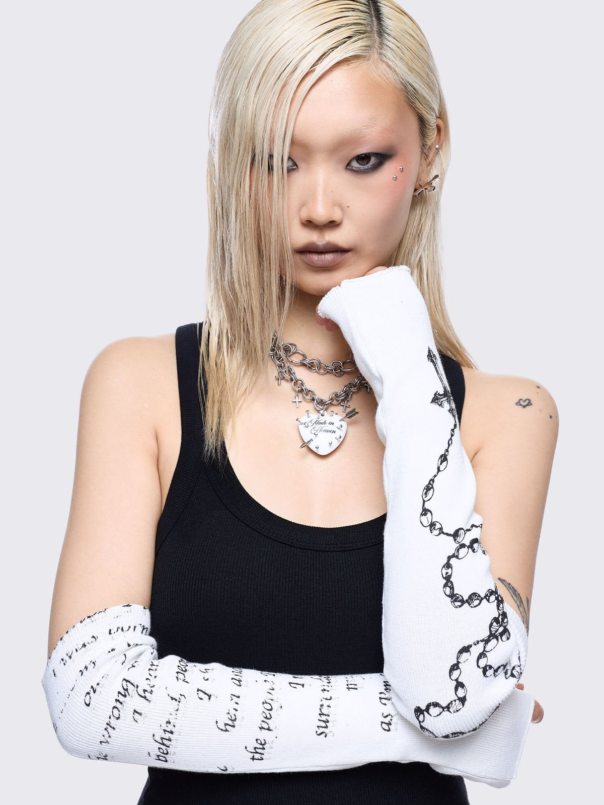 White knitted arm warmers with rosary and text graphic print.