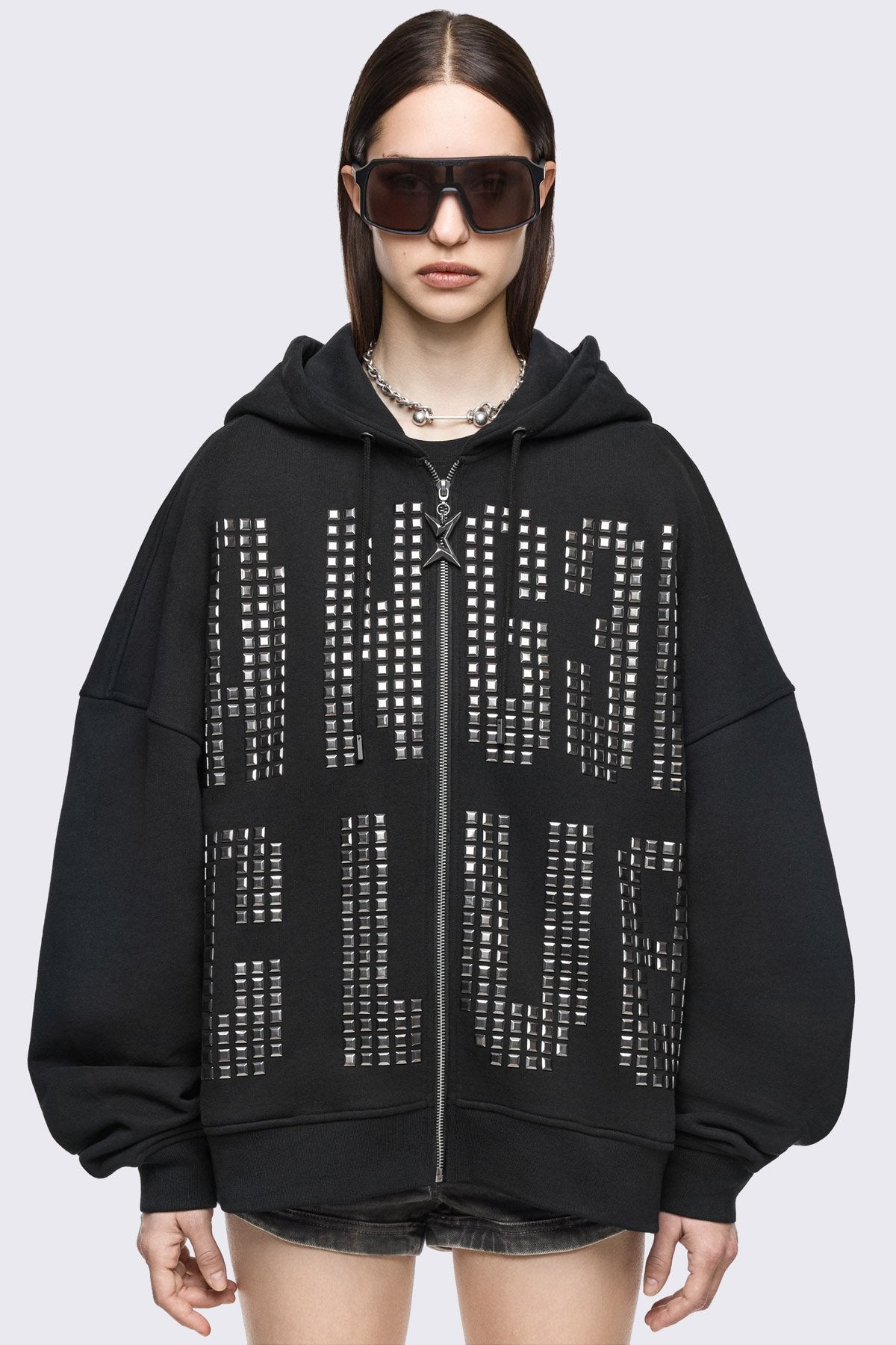 Black cotton zip-up hoodie with studded Angel Club design, oversized fit and grunge streetwear vibe.