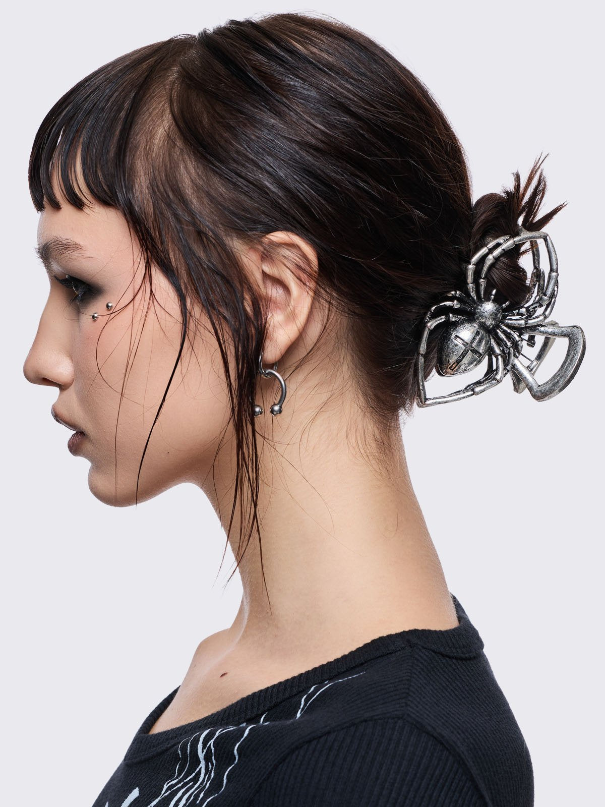 Metal hair claw clip with spider design.