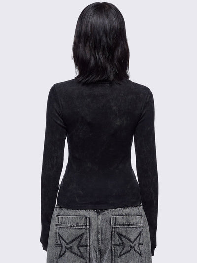 Black washed asymmetric top with cut-out and safety pin details.