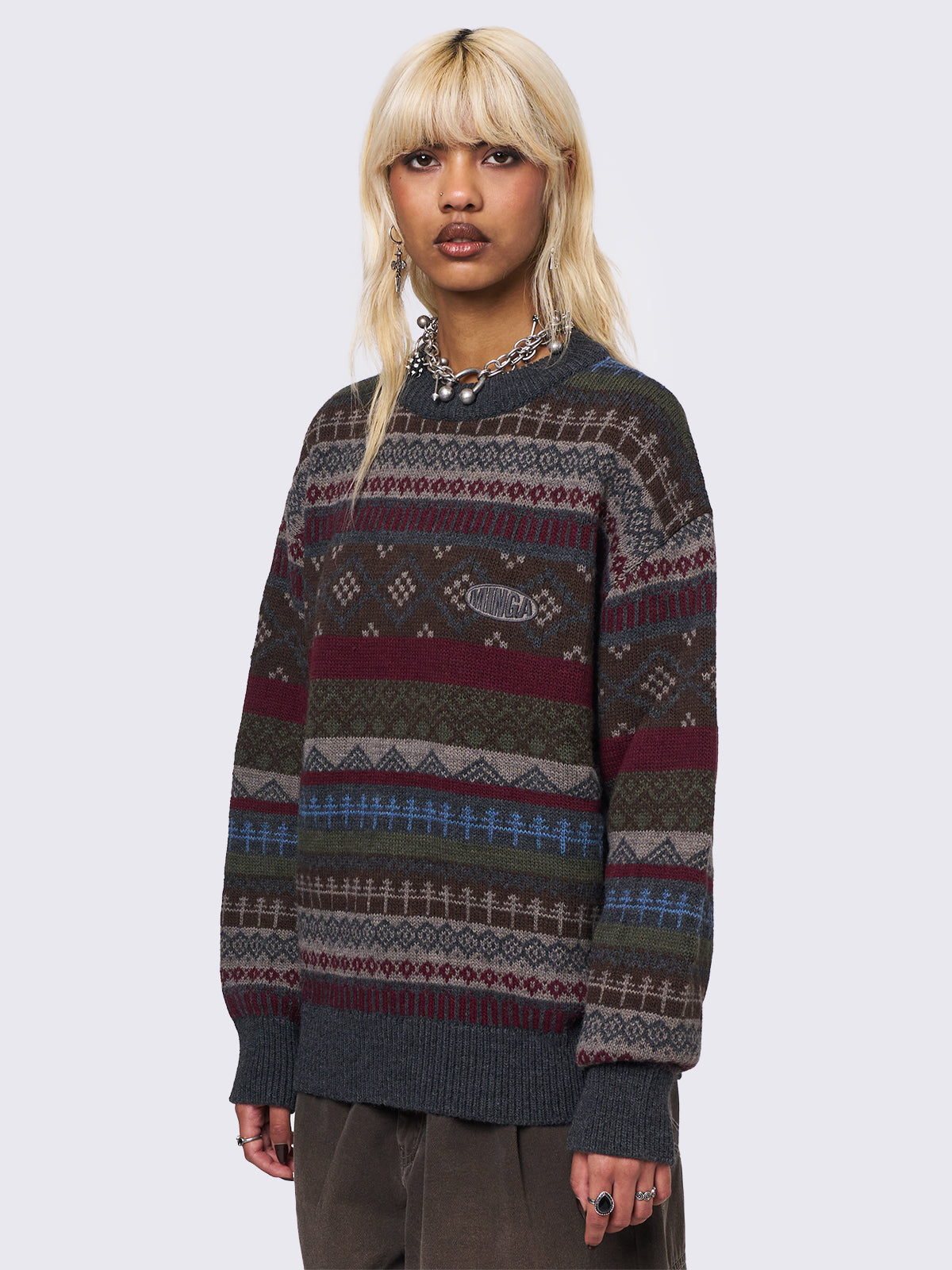 Jacquard knit jumper featuring geometric striped pattern in tones of grey, burgundy, green and blue.