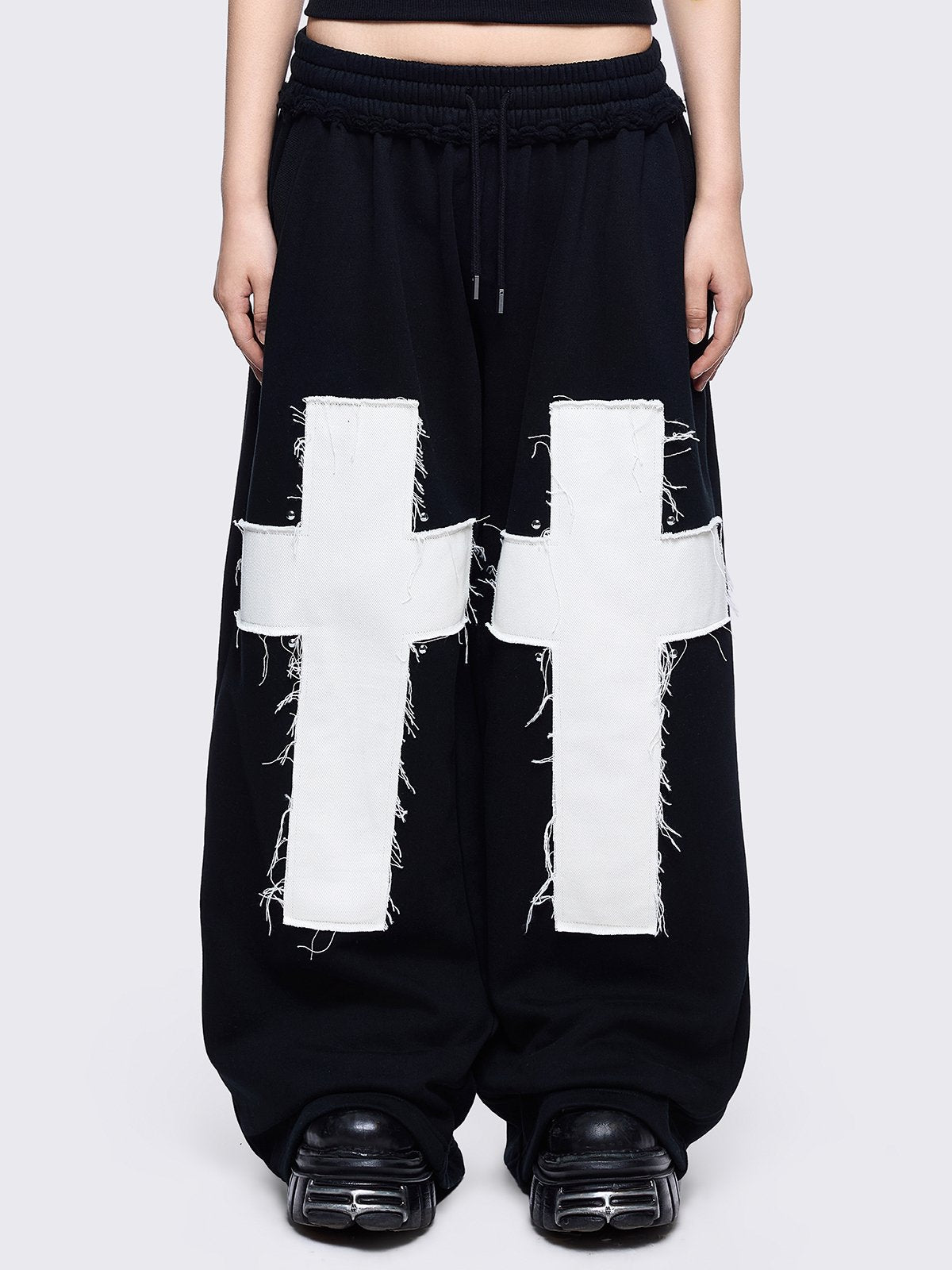 Black sweatpants with white chunky cross patches