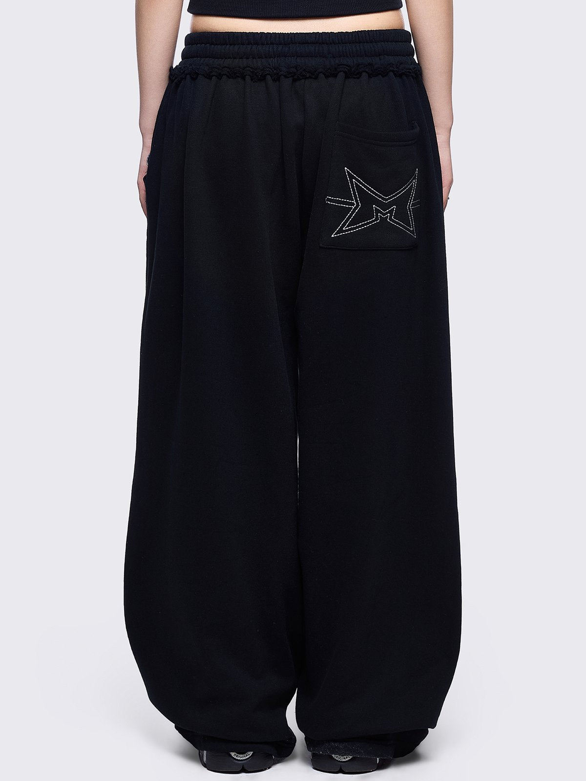Black sweatpants with white chunky cross patches