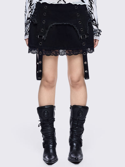 Black denim mini skirt with distressed frayed panels, lace up side details and eyelet straps.
