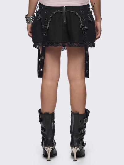 Black denim mini skirt with distressed frayed panels, lace up side details and eyelet straps.