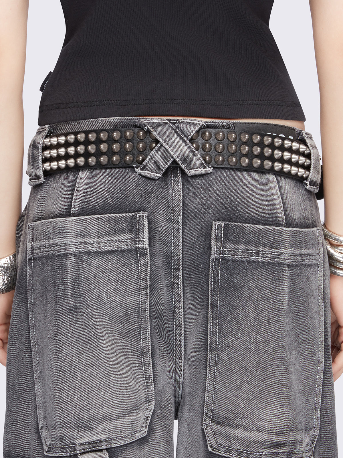 Black vegan leather belt featuring spike studs and square buckle fastening with double keeper.