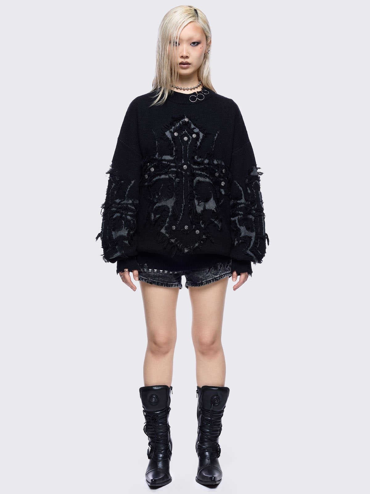 Black knitted jumper featuring frayed crosses design and stud and O-ring details.