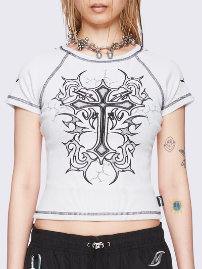 Off-white graphic raglan baby tee with tribal cross print and black contrast stitching.