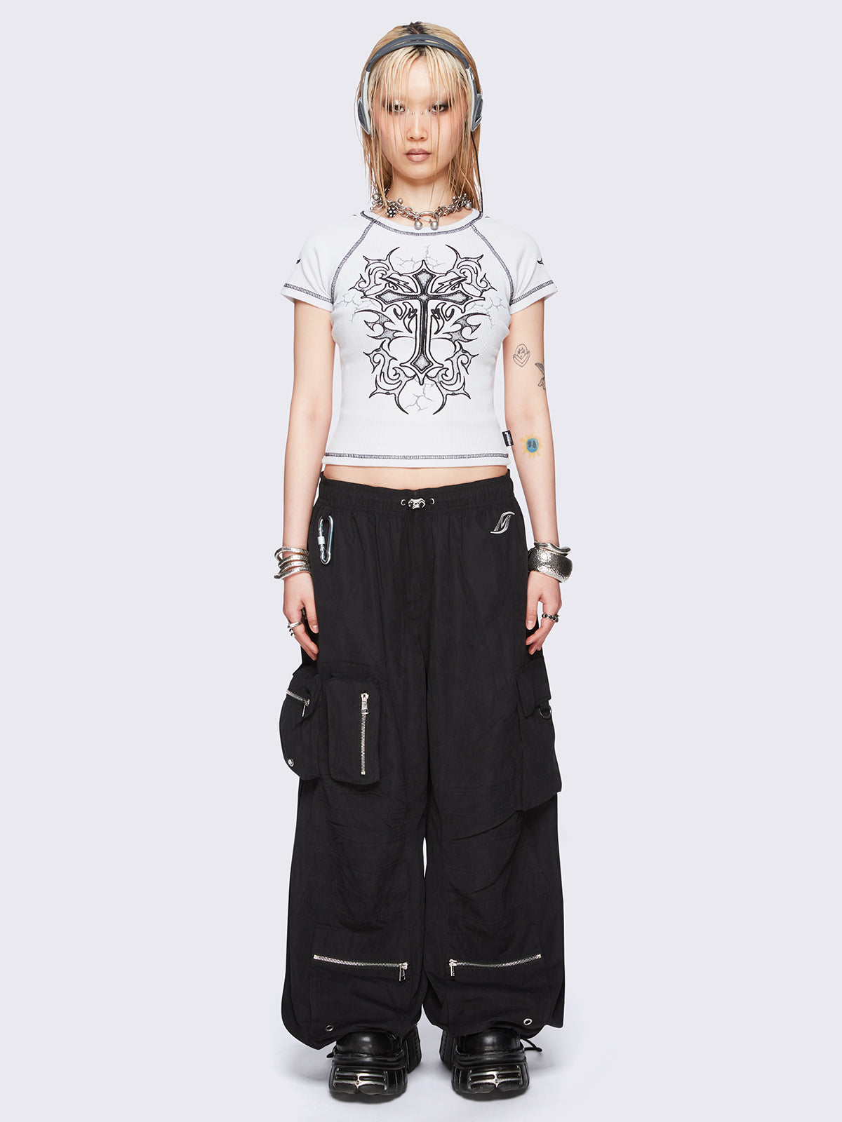 Off-white graphic raglan baby tee with tribal cross print and black contrast stitching.