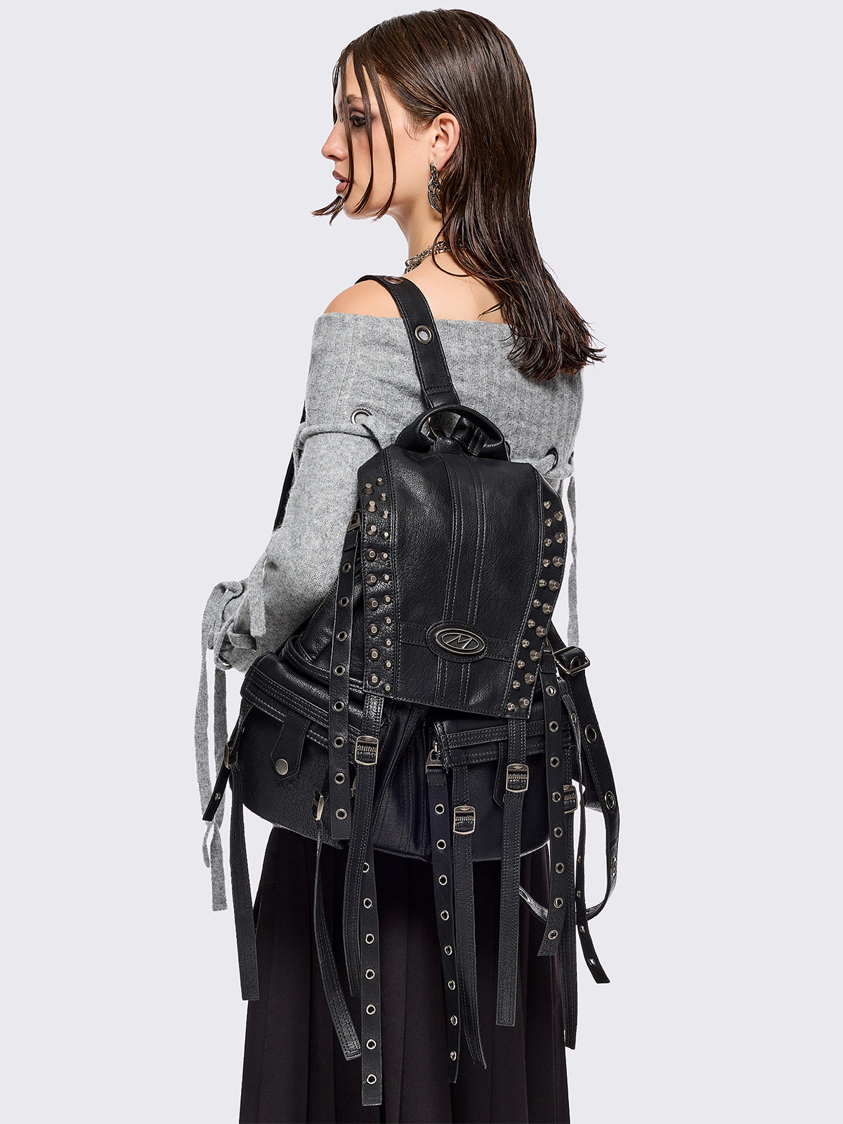 Black vegan leather backpack featuring silver stud, eyelet and strap details.