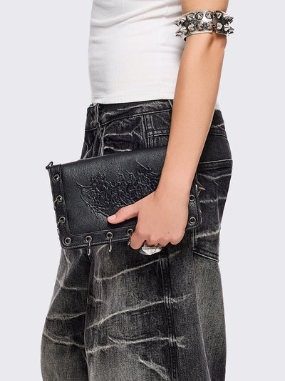 Black faux leather wallet with sigilism embossed graphic and silver eyelet and O-ring details.