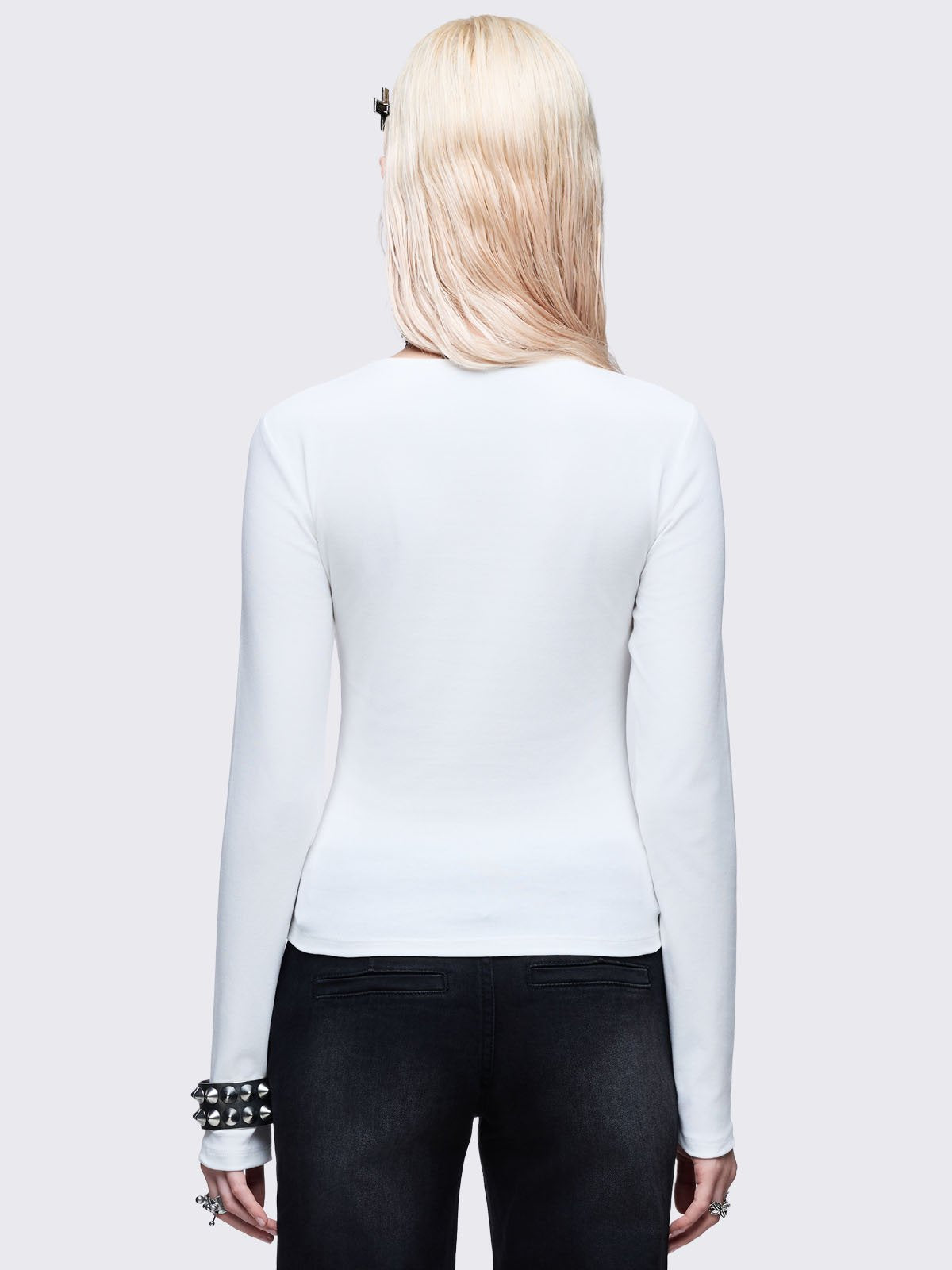 White long sleeve top with black chunky cross with silver studs