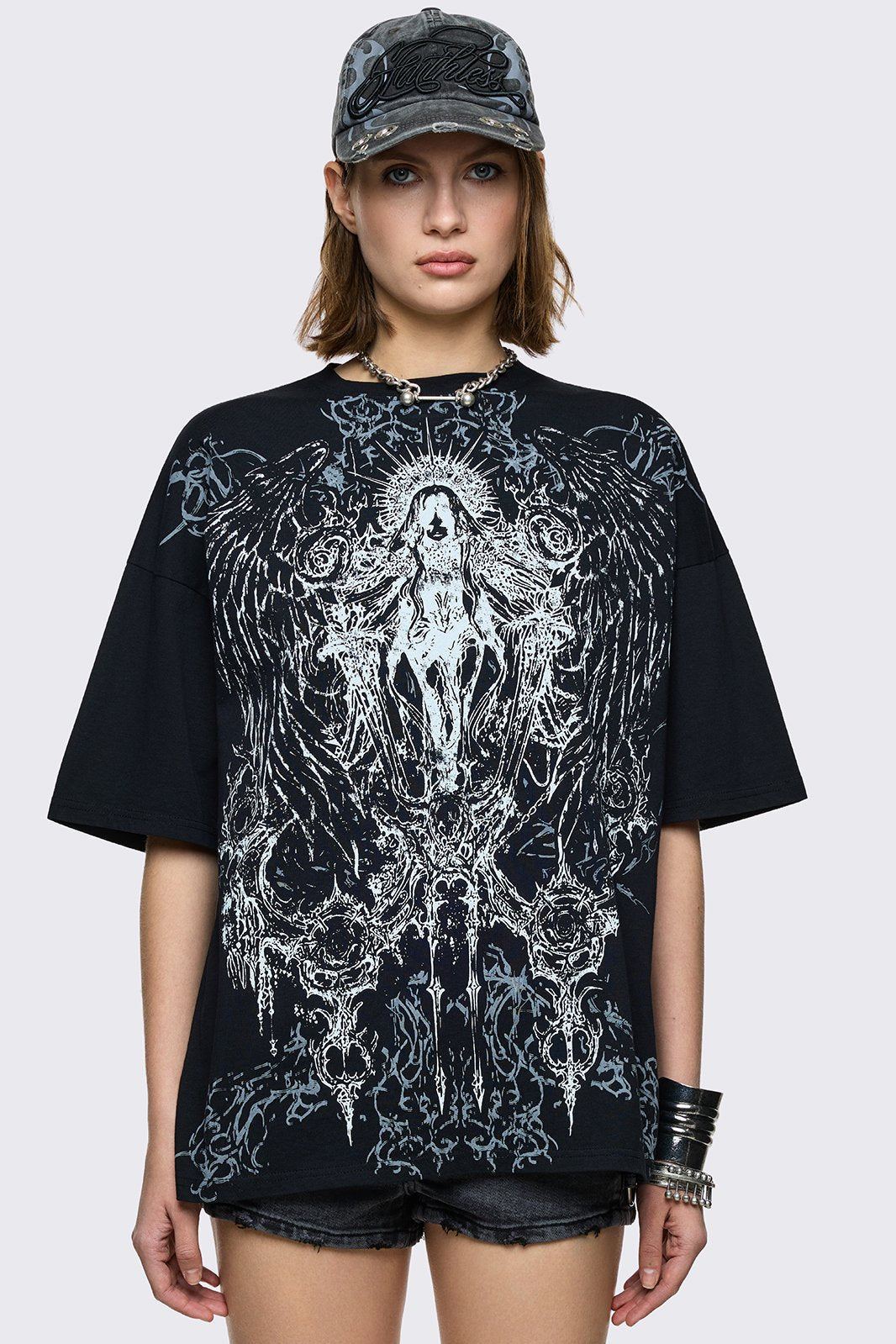 Black oversized t-shirt with winged dark saint graphic print. 