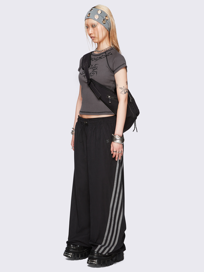 Black parachute pants with grey side stripes. 
