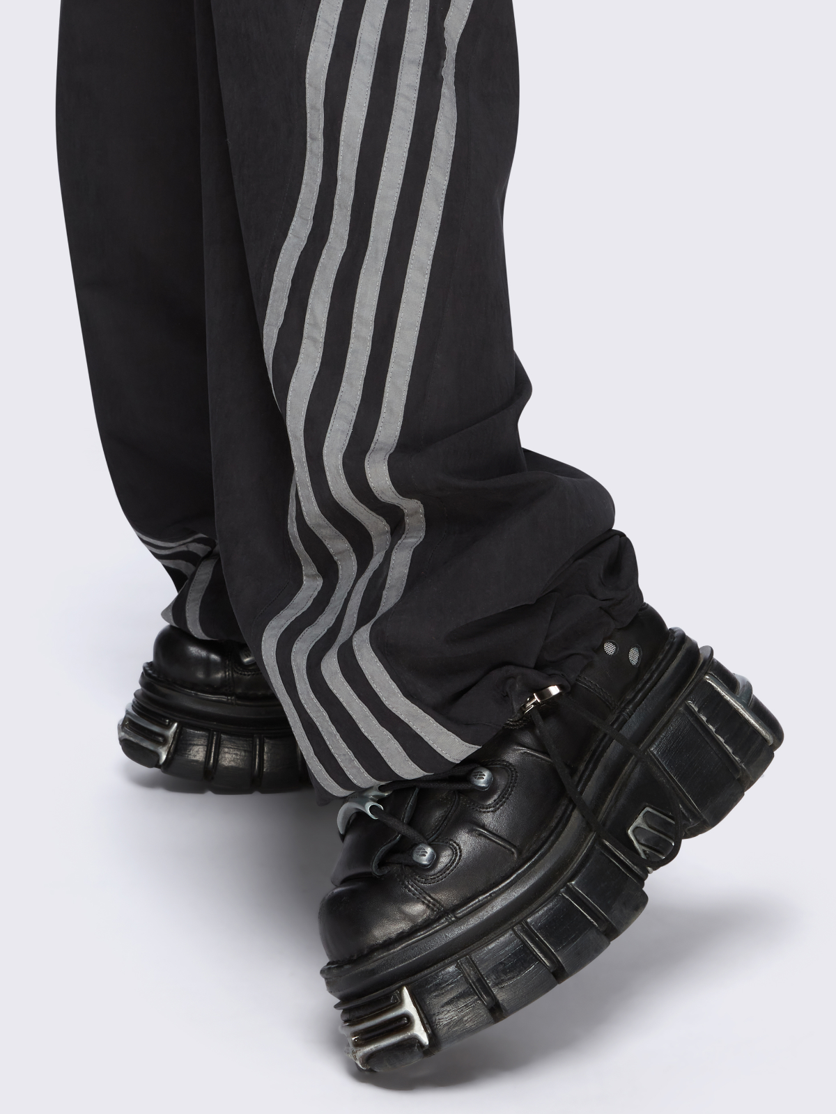 Black parachute pants with grey side stripes. 