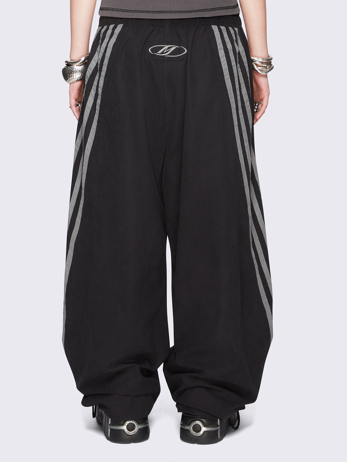 Black parachute pants with grey side stripes. 