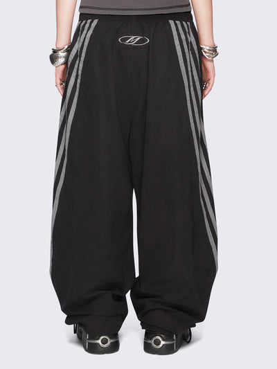 Black parachute pants with grey side stripes. 