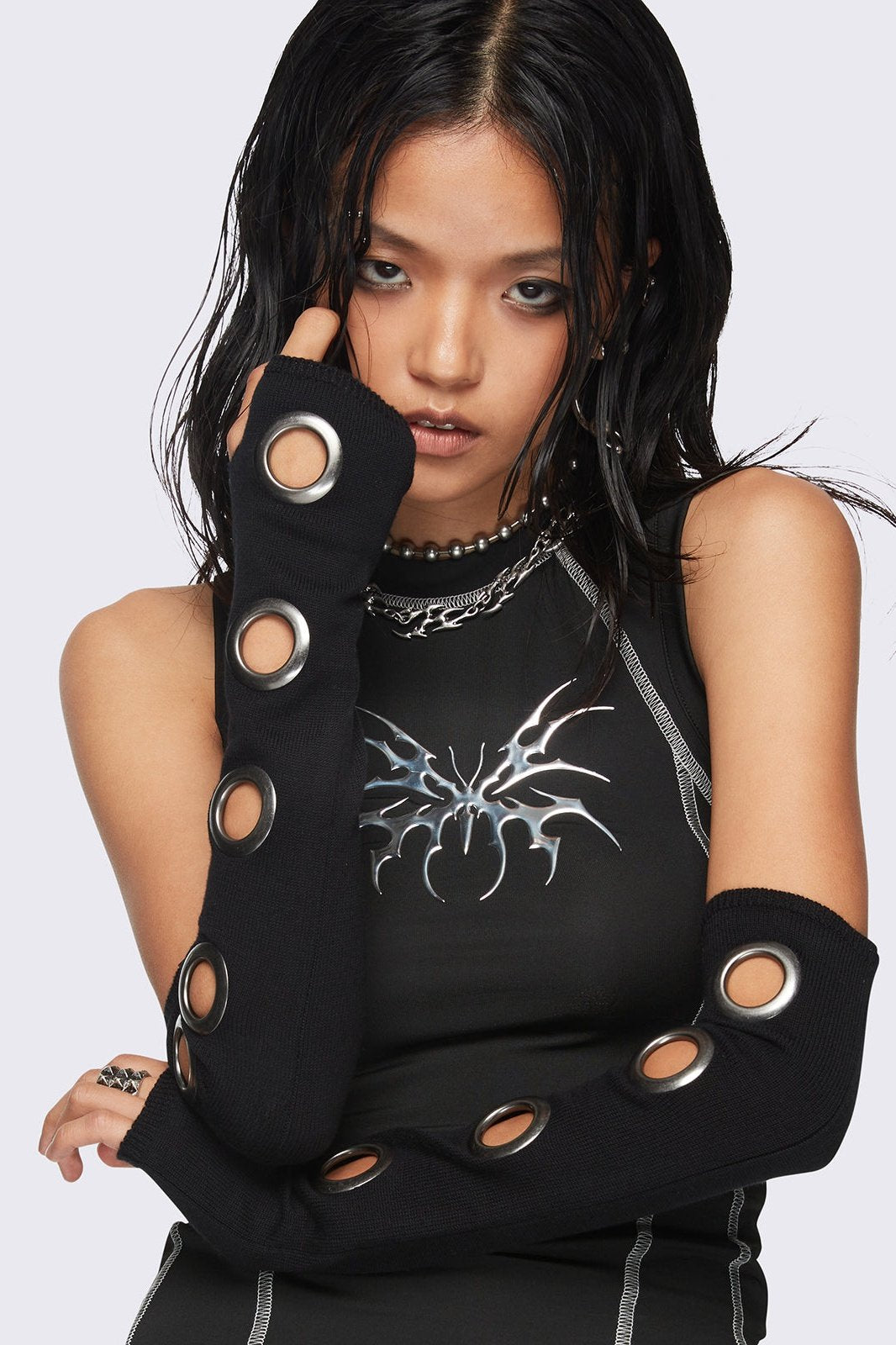 Black arm warmers with metallic hole details and thumbhole cuffs.