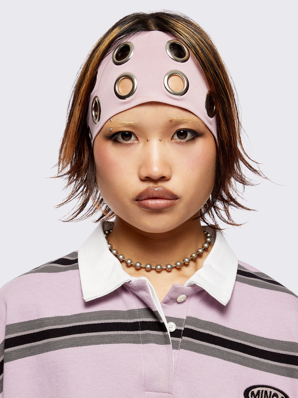 Headband in baby pink with chunky silver eyelets. 