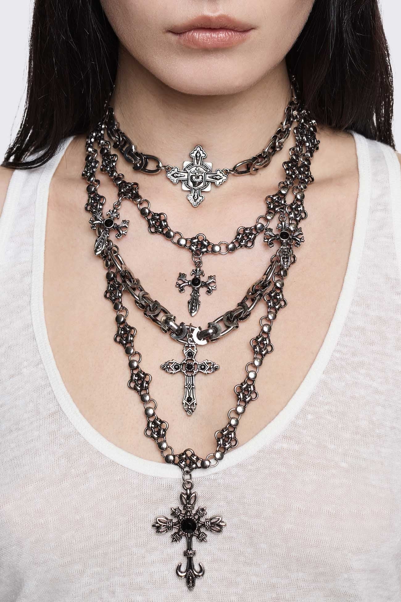 Layered necklace in antique-silver plated metal with mixed cross pendants and chains, in a goth grunge style.